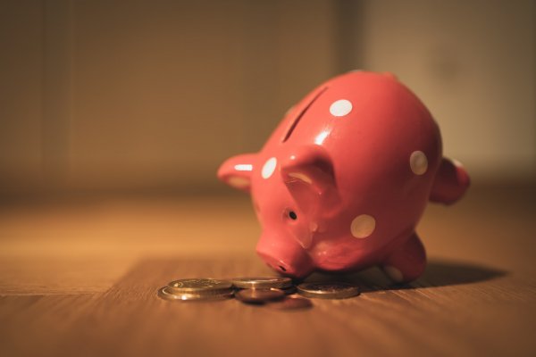 piggy bank with coins around it